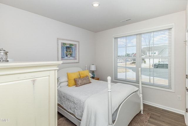 bedroom with visible vents, baseboards, and wood finished floors