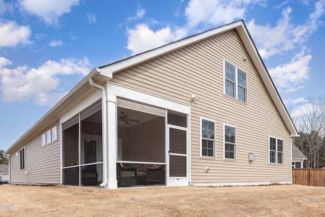 rear view of property featuring a yard and a sunroom