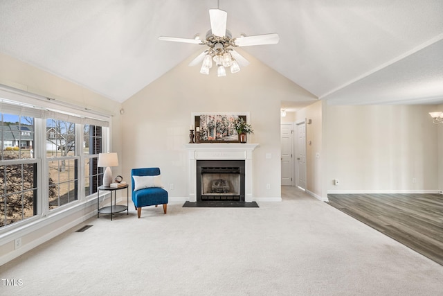 living area featuring visible vents, a fireplace with flush hearth, baseboards, and carpet flooring