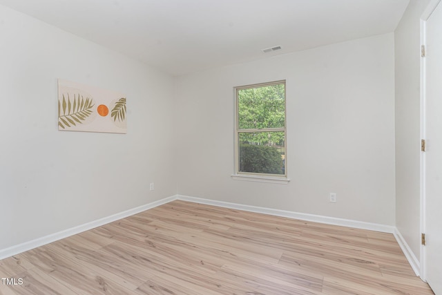 unfurnished room featuring baseboards, visible vents, and light wood-type flooring