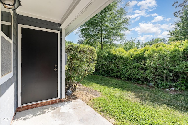 doorway to property with a lawn