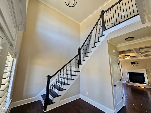 staircase featuring ornamental molding, coffered ceiling, baseboards, and wood finished floors