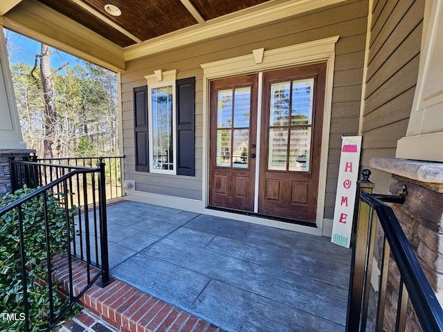 entrance to property featuring a balcony and covered porch