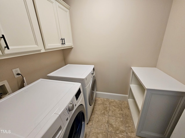 laundry area featuring baseboards, cabinet space, separate washer and dryer, and light tile patterned flooring