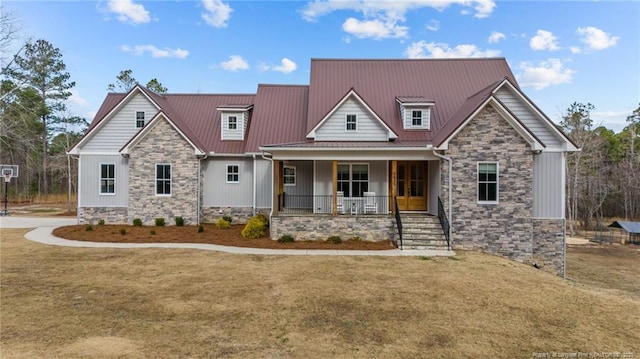 craftsman inspired home featuring a porch, a front yard, and metal roof