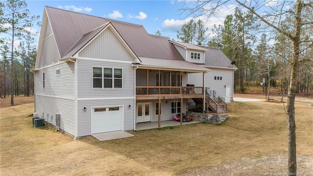 rear view of property featuring dirt driveway, french doors, stairway, metal roof, and a patio area