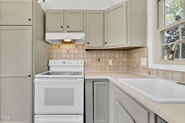 kitchen featuring a sink, light countertops, under cabinet range hood, and white range with electric cooktop