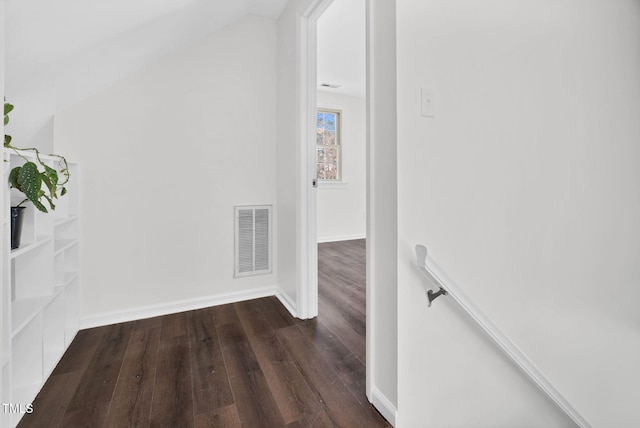 hall featuring visible vents, baseboards, lofted ceiling, and dark wood-style floors