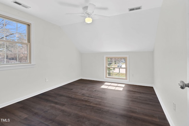 empty room featuring visible vents, wood finished floors, and vaulted ceiling