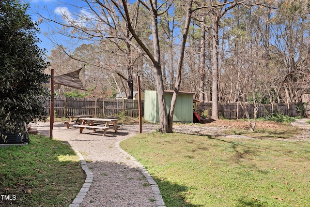 view of yard featuring an outbuilding, a storage unit, and a fenced backyard