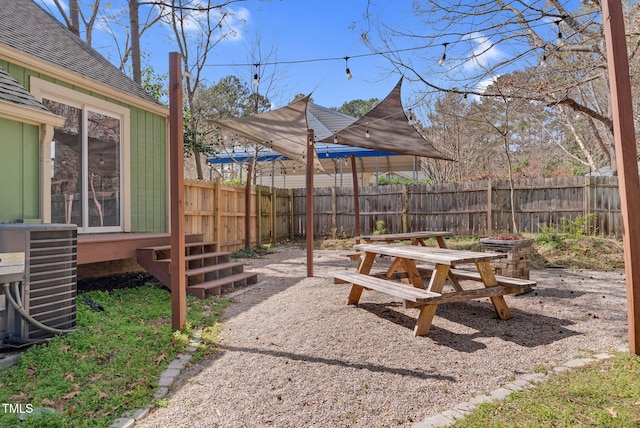 view of yard with central AC unit and fence