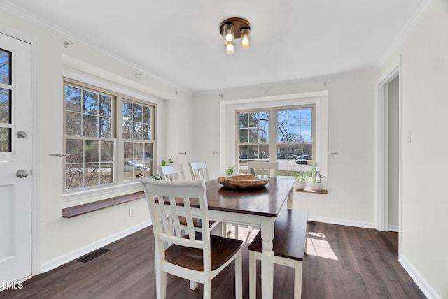 dining area with dark wood-type flooring, visible vents, and ornamental molding