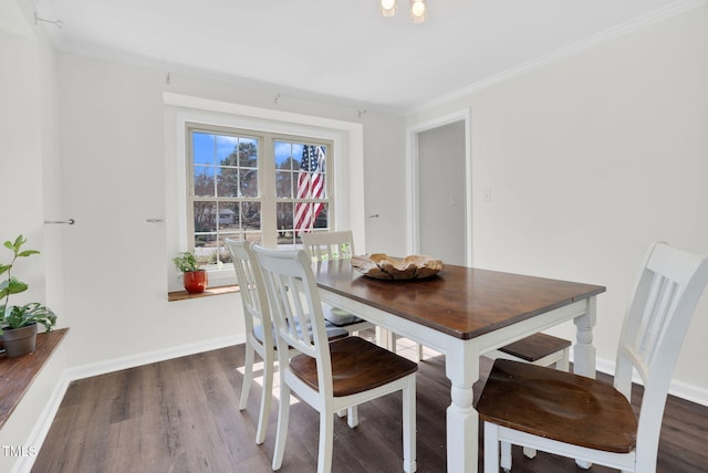 dining room with wood finished floors, baseboards, and ornamental molding