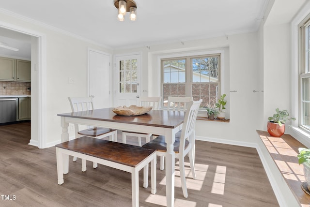 dining space with light wood-style floors, baseboards, and ornamental molding