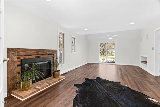 living area with visible vents, wood finished floors, recessed lighting, baseboards, and a brick fireplace