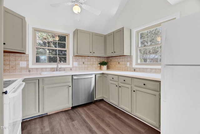 kitchen with a sink, tasteful backsplash, white appliances, dark wood-style flooring, and vaulted ceiling