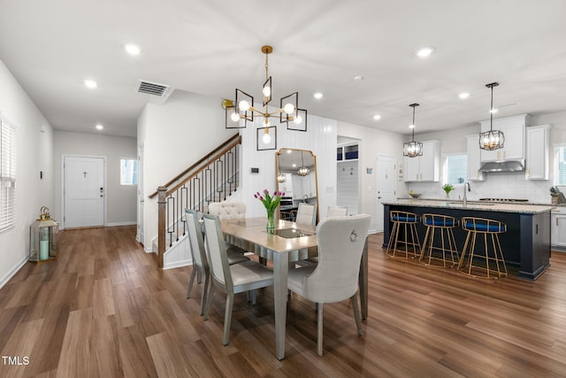 dining area with visible vents, dark wood-type flooring, a chandelier, stairs, and recessed lighting