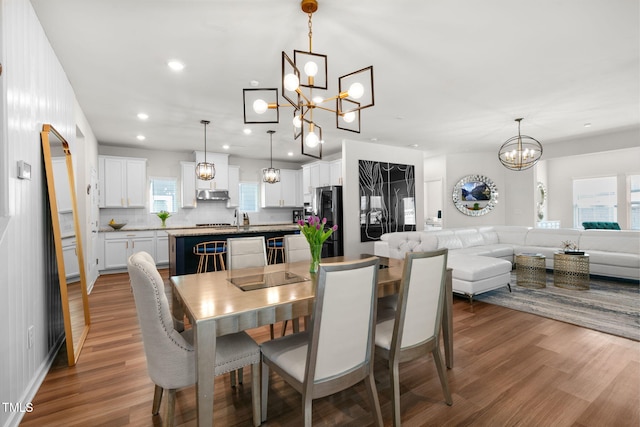 dining room featuring recessed lighting, wood finished floors, and a chandelier