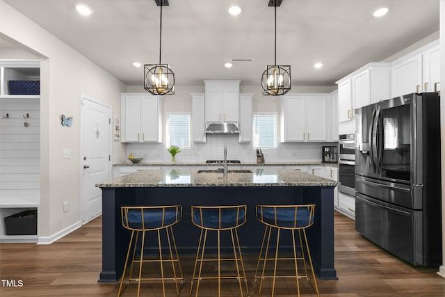 kitchen featuring under cabinet range hood, visible vents, white cabinetry, and stainless steel appliances