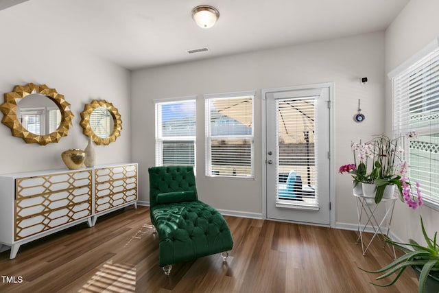 sitting room featuring visible vents, baseboards, and wood finished floors