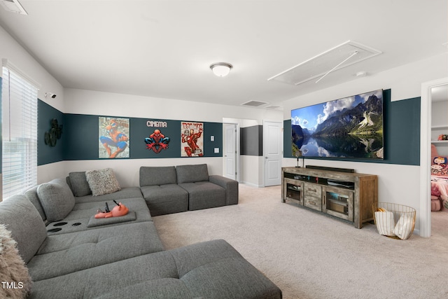 living area featuring visible vents, attic access, and carpet flooring