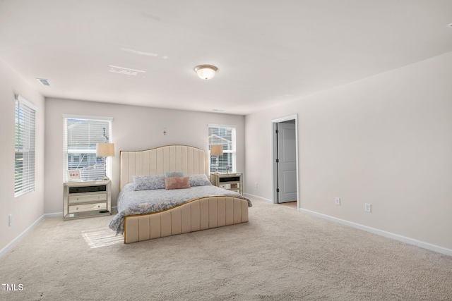 bedroom featuring multiple windows, baseboards, visible vents, and light carpet