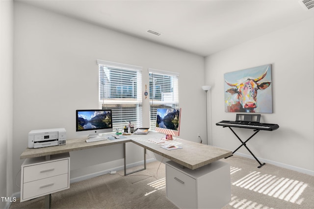 office space featuring baseboards, visible vents, and light carpet