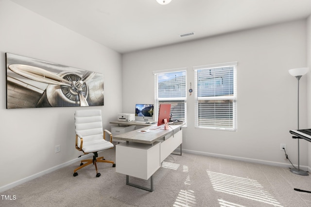 home office with baseboards, visible vents, and light carpet