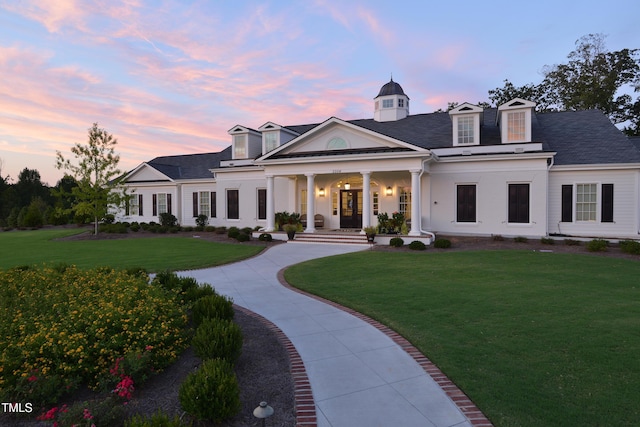 view of front of house with a porch, a yard, and driveway