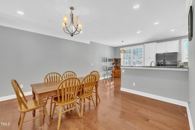 dining room with recessed lighting, baseboards, a notable chandelier, and light wood-style flooring