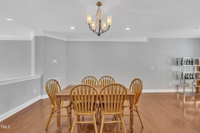 dining room featuring wood finished floors, baseboards, recessed lighting, ornamental molding, and a chandelier