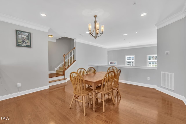 dining area with visible vents, ornamental molding, stairway, and wood finished floors