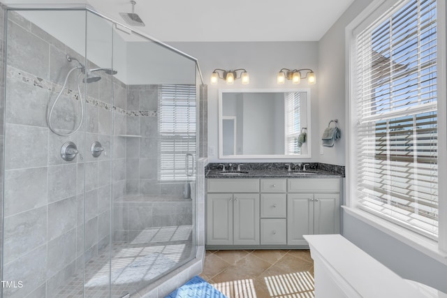 bathroom with a stall shower, a wealth of natural light, and a sink