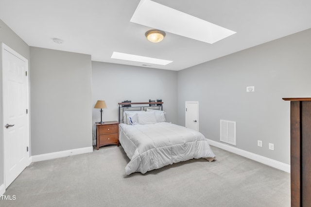 bedroom with a skylight, carpet, visible vents, and baseboards