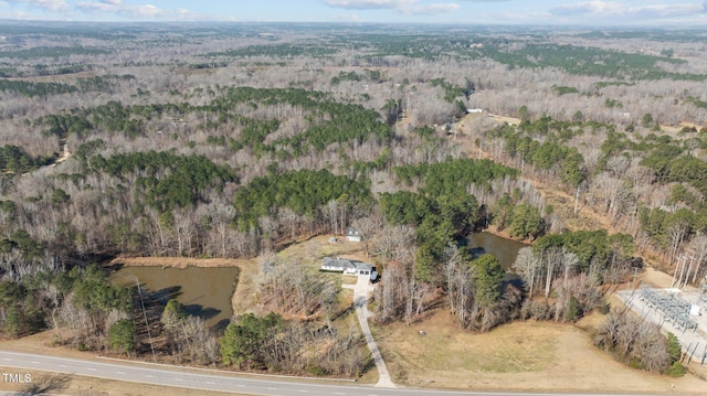 birds eye view of property with a wooded view and a water view