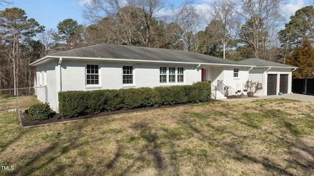 view of front facade featuring fence, an attached garage, a front lawn, concrete driveway, and brick siding