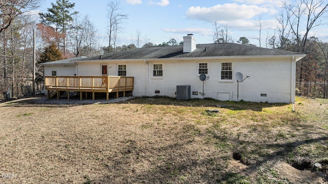 rear view of property featuring brick siding, a wooden deck, a lawn, a chimney, and crawl space