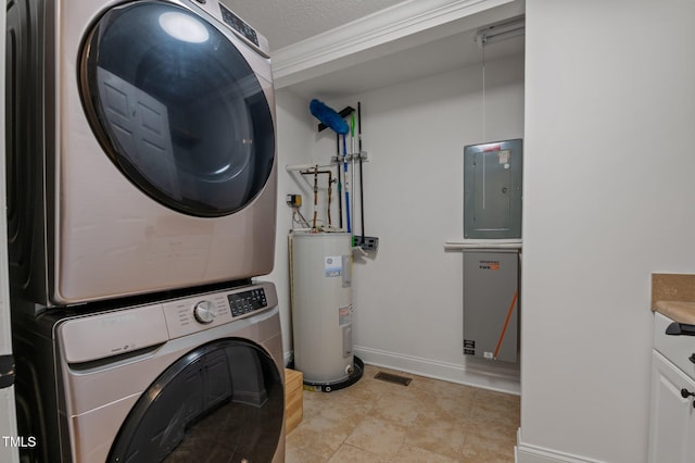 clothes washing area featuring baseboards, electric panel, cabinet space, water heater, and stacked washer and dryer