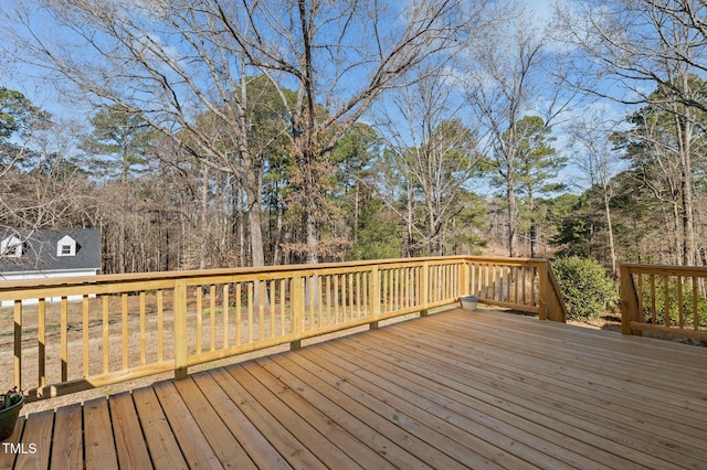 wooden terrace featuring a view of trees