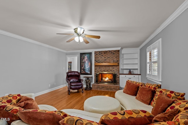 living room featuring baseboards, wood finished floors, a fireplace, and ornamental molding