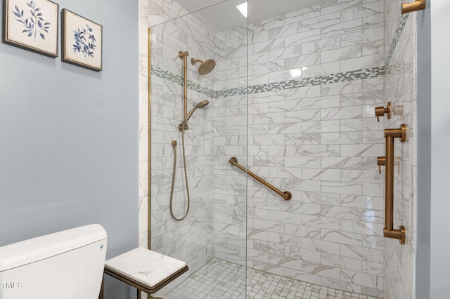 bathroom with a tile shower and toilet