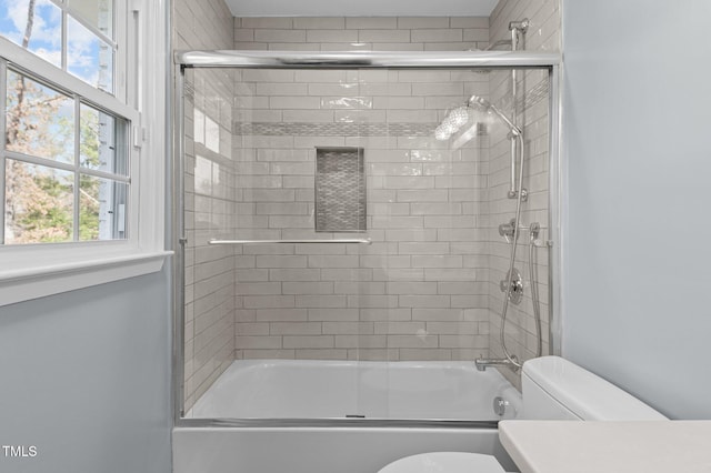 bathroom featuring combined bath / shower with glass door, toilet, and vanity