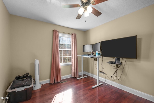 workout area with a ceiling fan, visible vents, wood finished floors, baseboards, and a textured ceiling