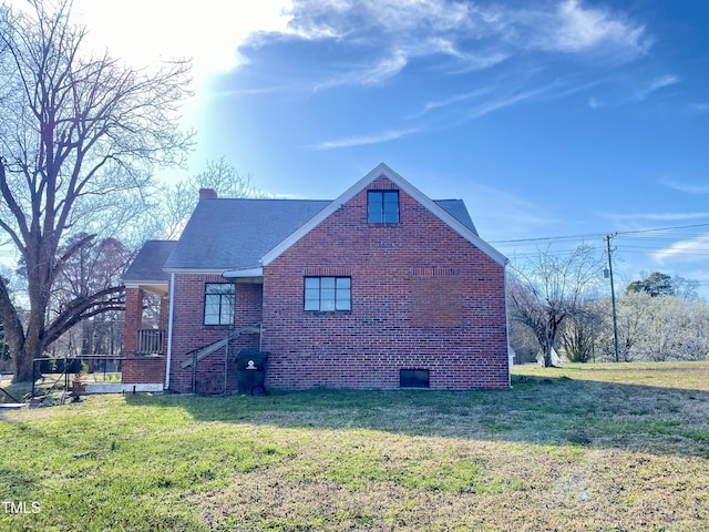 view of property exterior with brick siding, a lawn, and a chimney