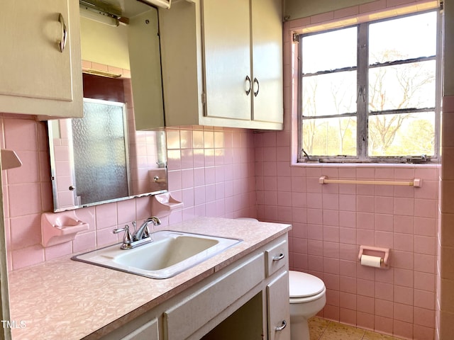 bathroom featuring vanity, tile walls, toilet, and tile patterned flooring