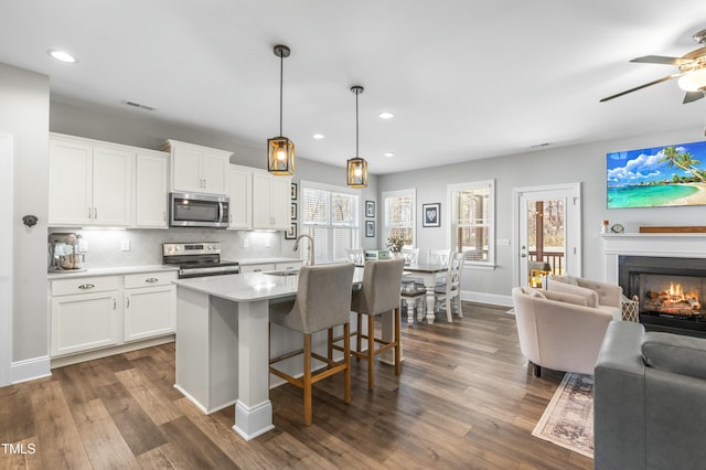 238 Ashpole Trl, Clayton, NC 27520 - kitchen featuring stainless steel appliances, open floor plan, dark wood-style floors, light countertops, and decorative backsplash