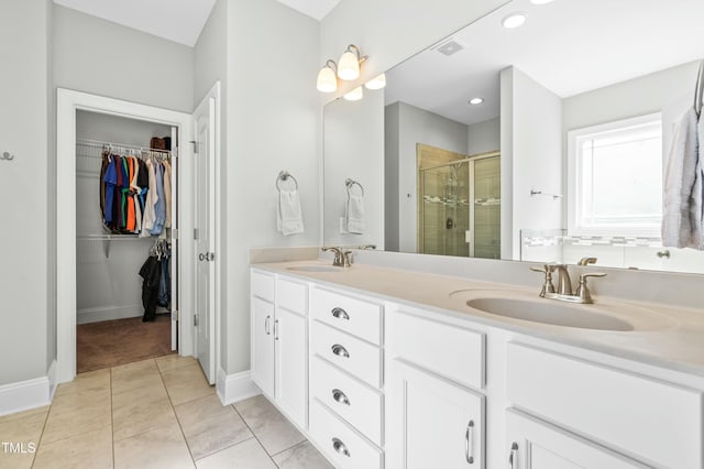 238 Ashpole Trl, Clayton, NC 27520 - bathroom with a shower stall, double vanity, a spacious closet, tile patterned floors, and recessed lighting