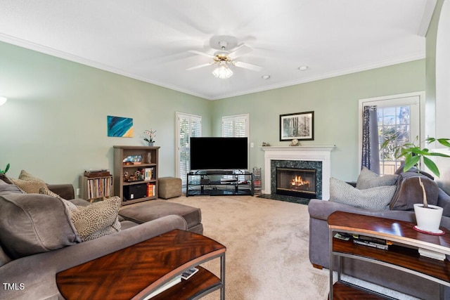 carpeted living area featuring crown molding, a ceiling fan, a wealth of natural light, and a premium fireplace