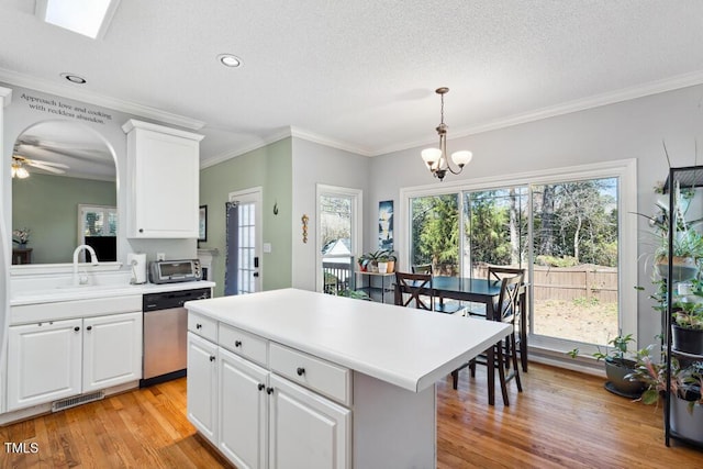 kitchen with visible vents, light wood finished floors, stainless steel dishwasher, white cabinetry, and light countertops