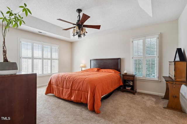 bedroom with carpet flooring, visible vents, baseboards, and a textured ceiling